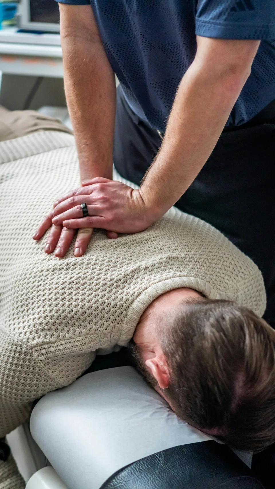Fisioterapista che esegue una terapia manuale sulla schiena di un paziente